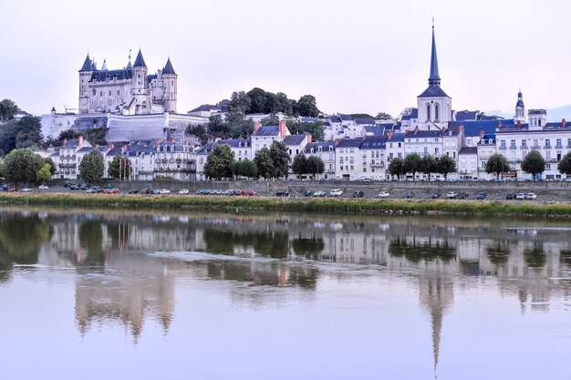 Uitzicht op de stad Saumur vanaf de rivieroever in de schemering