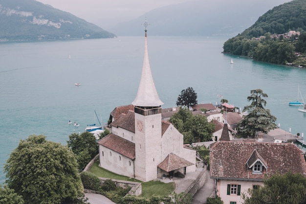 Uitzicht op de stad Spiez en het meer van Thun, Zwitserland, Europa. Zomerzondag, dramatische blauwe bewolkte lucht en verre bergen