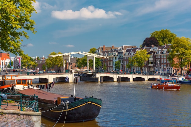 Uitzicht op de stad van Amsterdamse gracht Amstel, brug Magere Brug, boot en fietsen, Holland, Nederland.