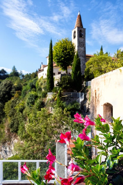 Uitzicht op de toren en bloemen op de voorgrond in het beroemde stadje Tremosine, Italië.