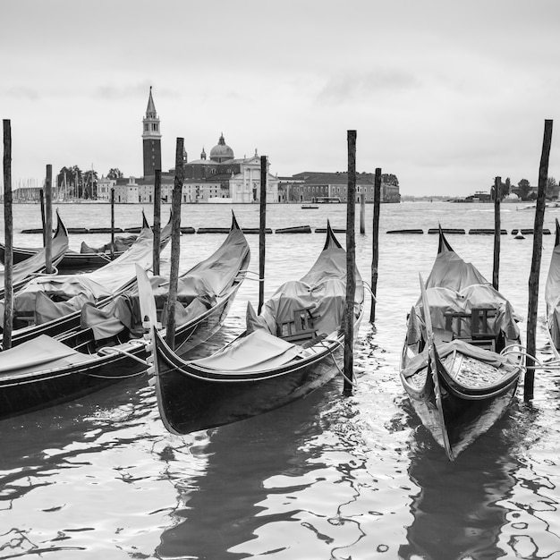 Uitzicht op de Venetiaanse lagune met afgemeerde gondels, Venetië, Italië. Zwart-wit afbeelding