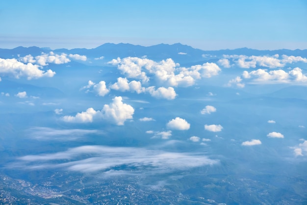 Uitzicht op de wolken en bergtoppen aan de horizon vanaf grote hoogte