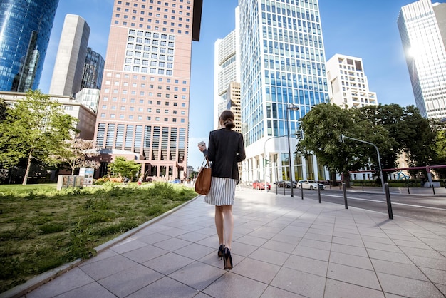 Uitzicht op de wolkenkrabbers met zakenvrouw die terugloopt in de moderne wijk in de stad frankfurt