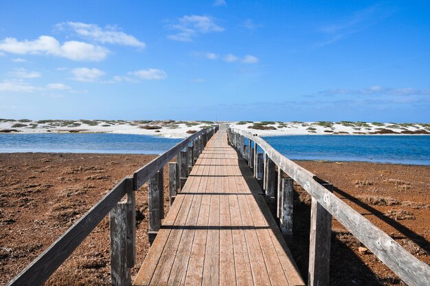 Uitzicht op een houten pier op het strand tegen de lucht