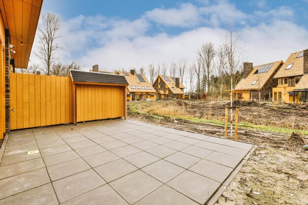 Uitzicht op een kleine achtertuin van een modern huisje betegeld in betonkleur