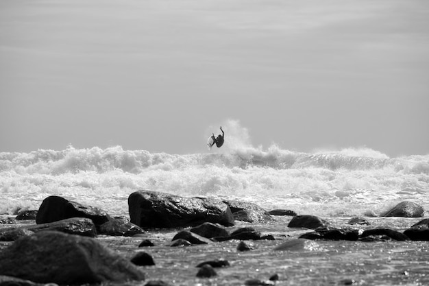 Uitzicht op een man die in de zee surft