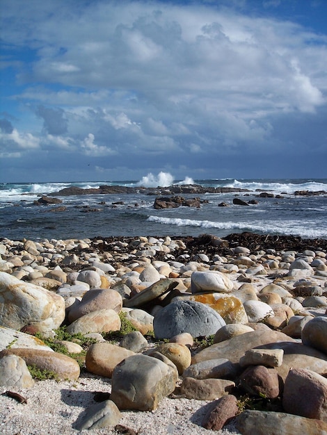 Uitzicht op een rustig strand tegen een bewolkte lucht