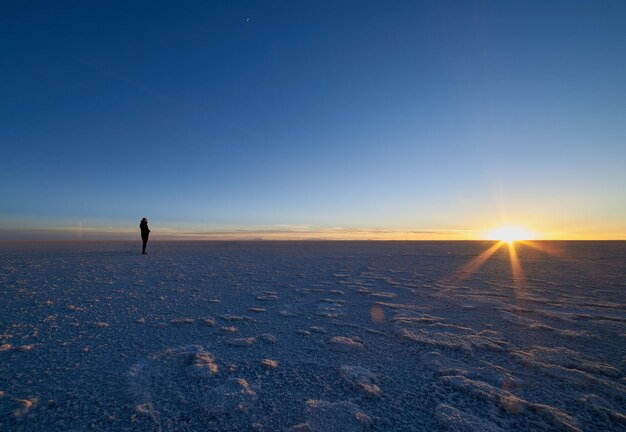 Uitzicht op een silhouetpersoon op een met sneeuw bedekt landschap