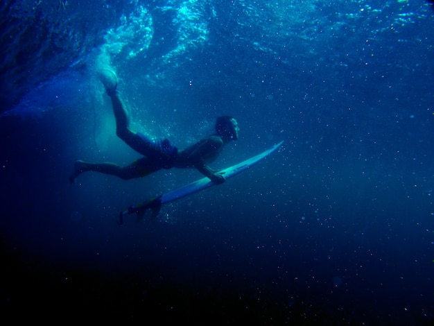 Uitzicht op een surfer die in de zee zwemt
