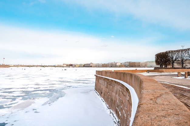 Uitzicht op hermitage (winterpaleis) vanaf de dijk van st. petersburg van de ijzige rivier de neva
