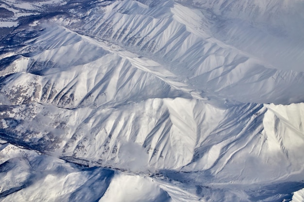 Uitzicht op het berglandschap vanuit een vliegtuig Besneeuwd panorama