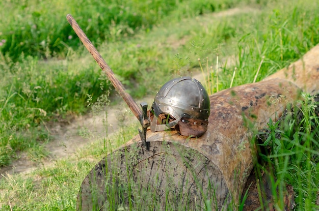 Uitzicht op het oude Viking-pantser liggend op een houten blok Helm en bijl Historisch fotoconcept
