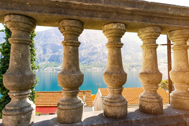 Uitzicht op het prachtige landschap van Perast door oude zuilen