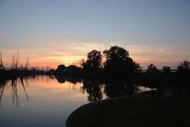 Uitzicht op het rustige meer bij zonsondergang