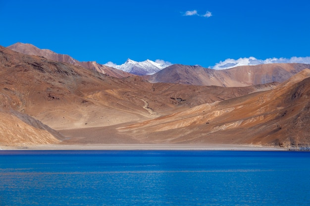 Uitzicht op majestueuze rotsachtige bergen tegen de blauwe lucht en het meer Pangong in de Indiase Himalaya, regio Ladakh, Jammu en Kasjmir, India. Natuur- en reisconcept