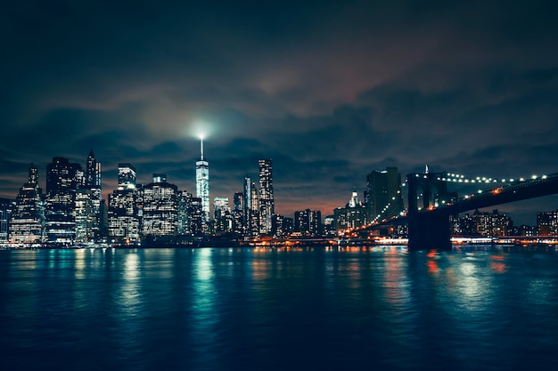 Uitzicht op new york met brooklyn bridge bij nacht, verenigde staten.