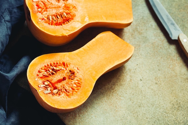 Uitzicht op rauwe pompoenhelften op een keukentafel Seizoensgebonden plantaardig voedsel stilleven