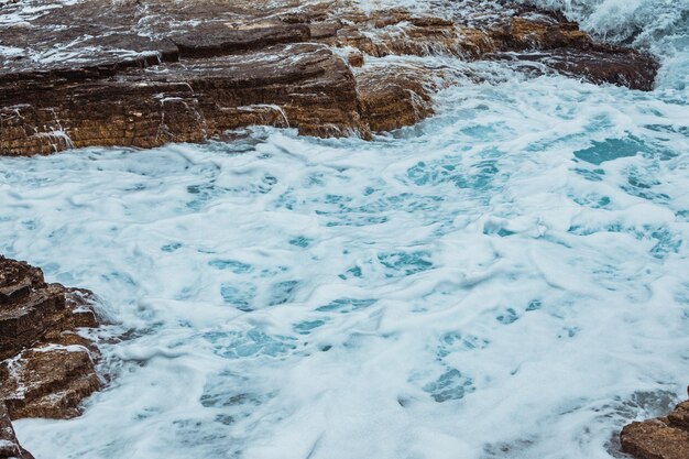 Uitzicht op rotsachtig zeestrand bij stormweer