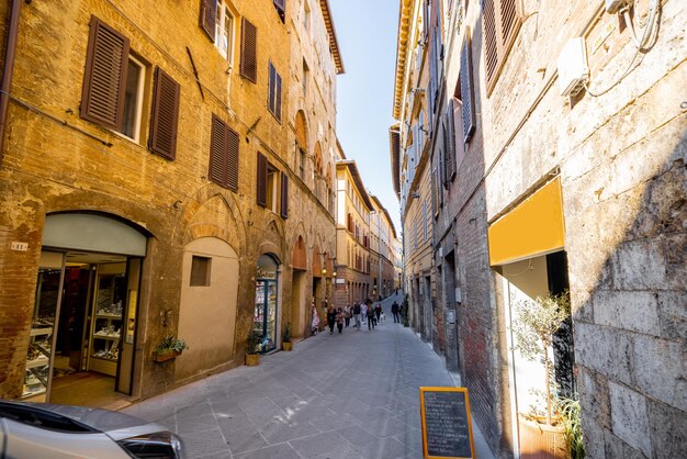 Uitzicht op smalle en gezellige straat in Siena, Italië