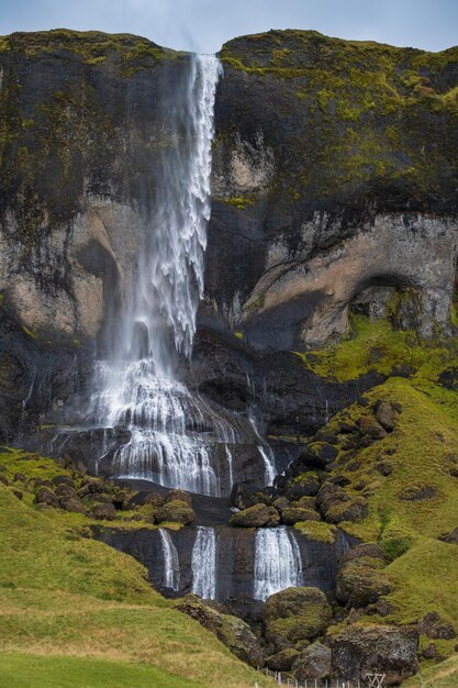 Uitzicht op waterval tijdens autorit in IJsland Spectaculair IJslands landschap met schilderachtige natuur