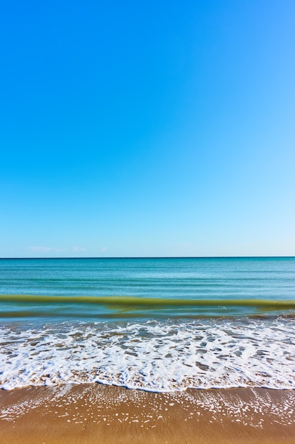 Uitzicht op zee met zandstrand en helderblauwe lucht