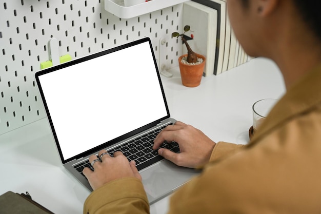 Uitzicht over de schouder van een zakenman die met een laptop werkt