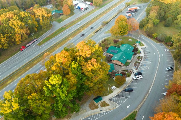 Uitzicht van boven op een groot parkeerterrein voor auto's en vrachtwagens in de buurt van een drukke Amerikaanse snelweg met snel verkeer Recreatieplaats tijdens interstate reizen