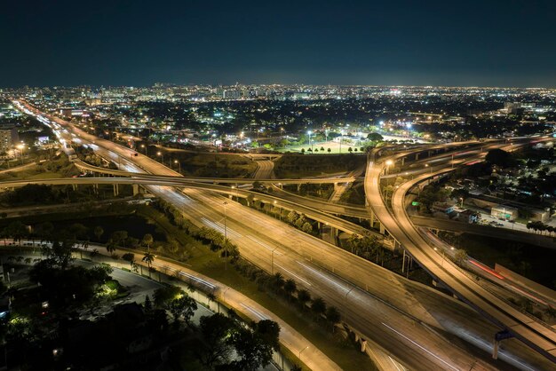 Uitzicht van bovenaf op het amerikaanse grote snelwegkruispunt in miami florida 's nachts met snel bewegende auto's en vrachtwagens vs-transportinfrastructuurconcept