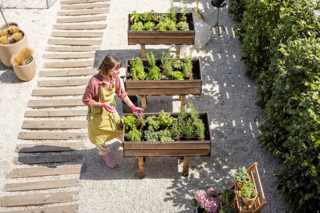 Uitzicht van bovenaf op moestuin en vrouw aan het werk