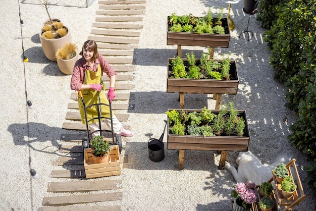 Uitzicht van bovenaf op moestuin en vrouw aan het werk