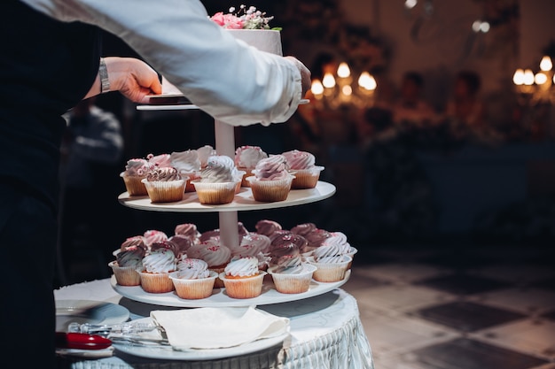 Uitzicht vanaf achterkant ober serveert cake en cupcakes