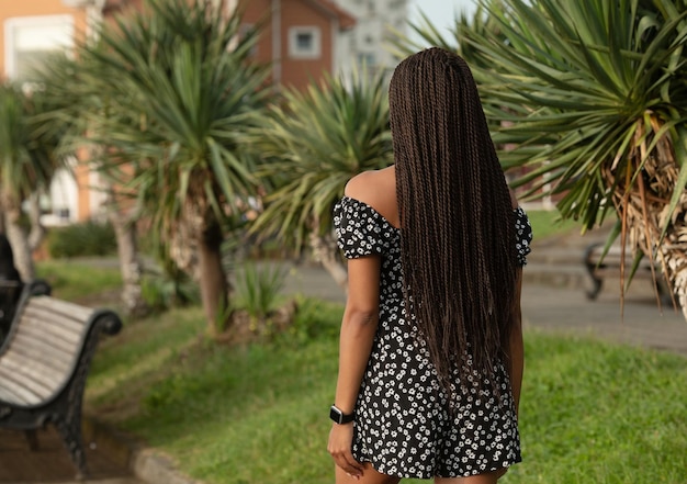 Uitzicht vanaf de achterkant van het meisje met zwarte dreadlocks van kanekalon.