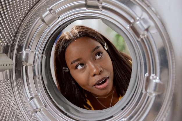 Uitzicht vanaf de binnenkant van de trommel een vrouw heeft een nieuwe wasmachine gekocht bekijkt hem zorgvuldig van binnen