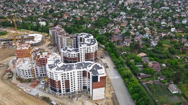 Uitzicht vanaf de drone op de hoogbouw die naast de huisjes wordt gebouwd.