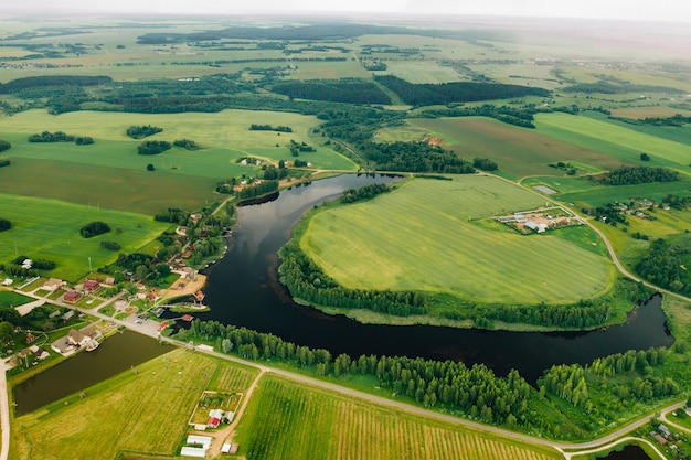 Uitzicht vanaf de hoogte van het meer in een groen veld in de vorm van een hoefijzer en een dorp in de regio Mogilev