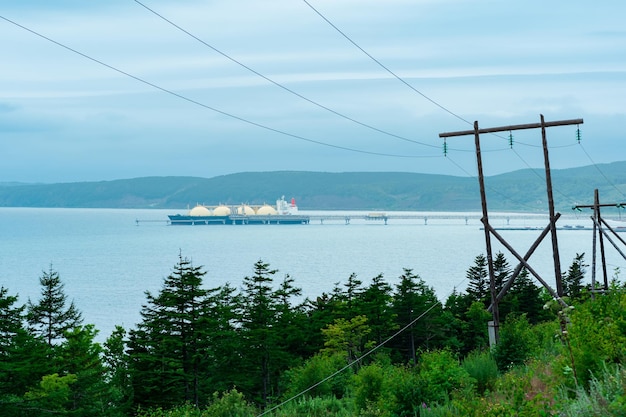 Uitzicht vanaf de kust van Sakhalin naar de LNG offshore terminal met een afgemeerde gastanker