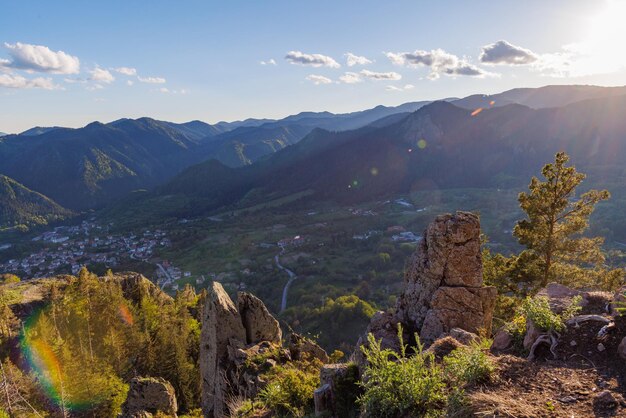 Uitzicht vanaf de rots naar de stad Smolyan met weiden waar vee kan wandelen en huizen tussen de bergketen van het Rodopegebergte