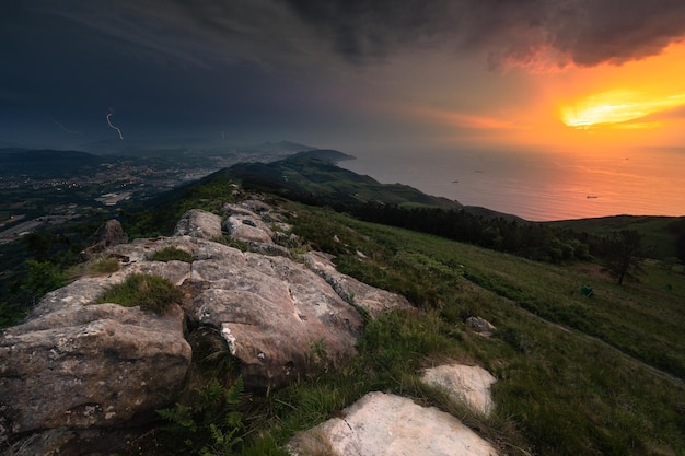 Uitzicht vanaf de top van de jaizkibel-berg met een prachtige zonsondergang en een onweersbui