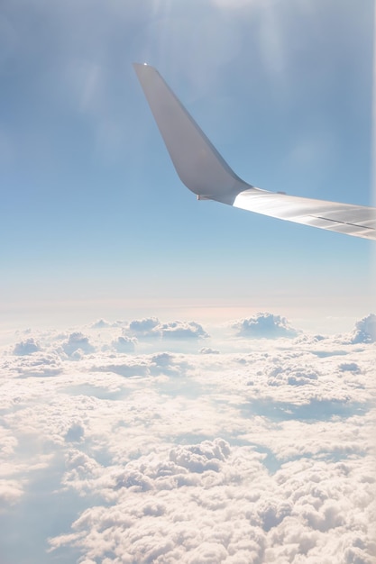 Uitzicht vanaf de vleugel van het vliegdekschip en de glorieuze blauwe lucht met prachtige cumulus van witte wolken Vakantiereizen met het vliegtuig Verticaal beeld Vopy-ruimte