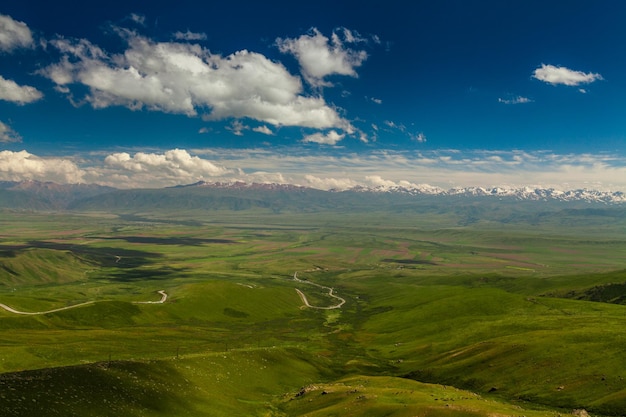 Uitzicht vanaf pas naar groene vallei en de bergen Kirgizië