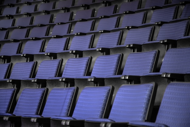 Uitzicht vanaf trappen op rijen comfortabele blauwe stoelen in theater of bioscoop. Curve van blauwe stoelen