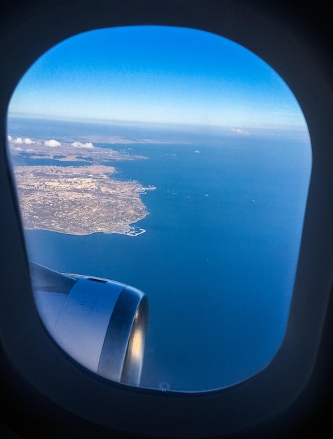 Uitzicht vanuit het vliegtuigraam, lucht en oceaanblauw