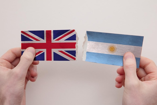 UK and Argentina paper flags ripped apart political relationship concept