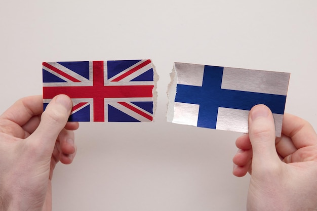 UK and Finland paper flags ripped apart political relationship concept