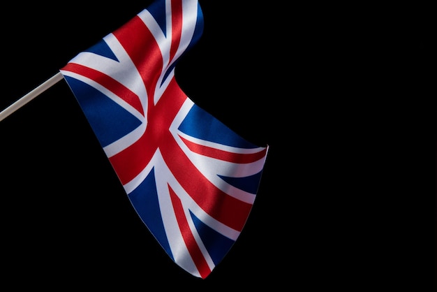 Photo the uk flag on a dark background waving in the wind