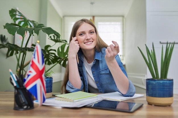 Foto regno unito che impara l'inglese online studentessa che guarda a distanza la webcam