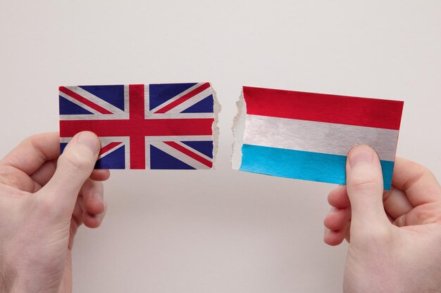 UK and Luxembourg paper flags ripped apart political relationship concept