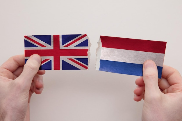 UK and Netherlands paper flags ripped apart political relationship concept