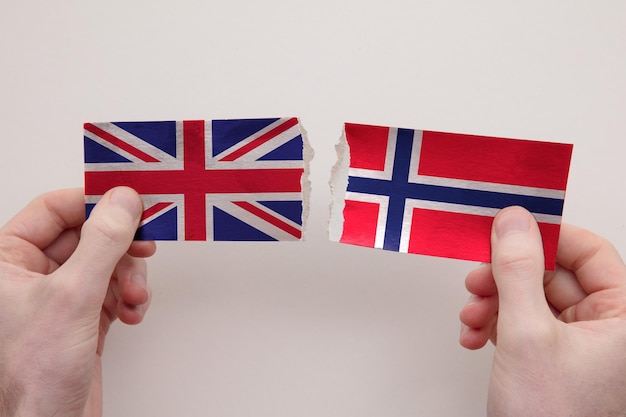 Uk and norway paper flags ripped apart political relationship concept