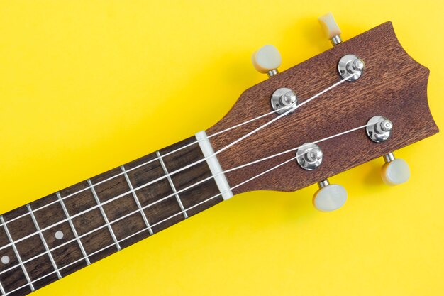 Ukelele fretboard op heldere gele achtergrond.